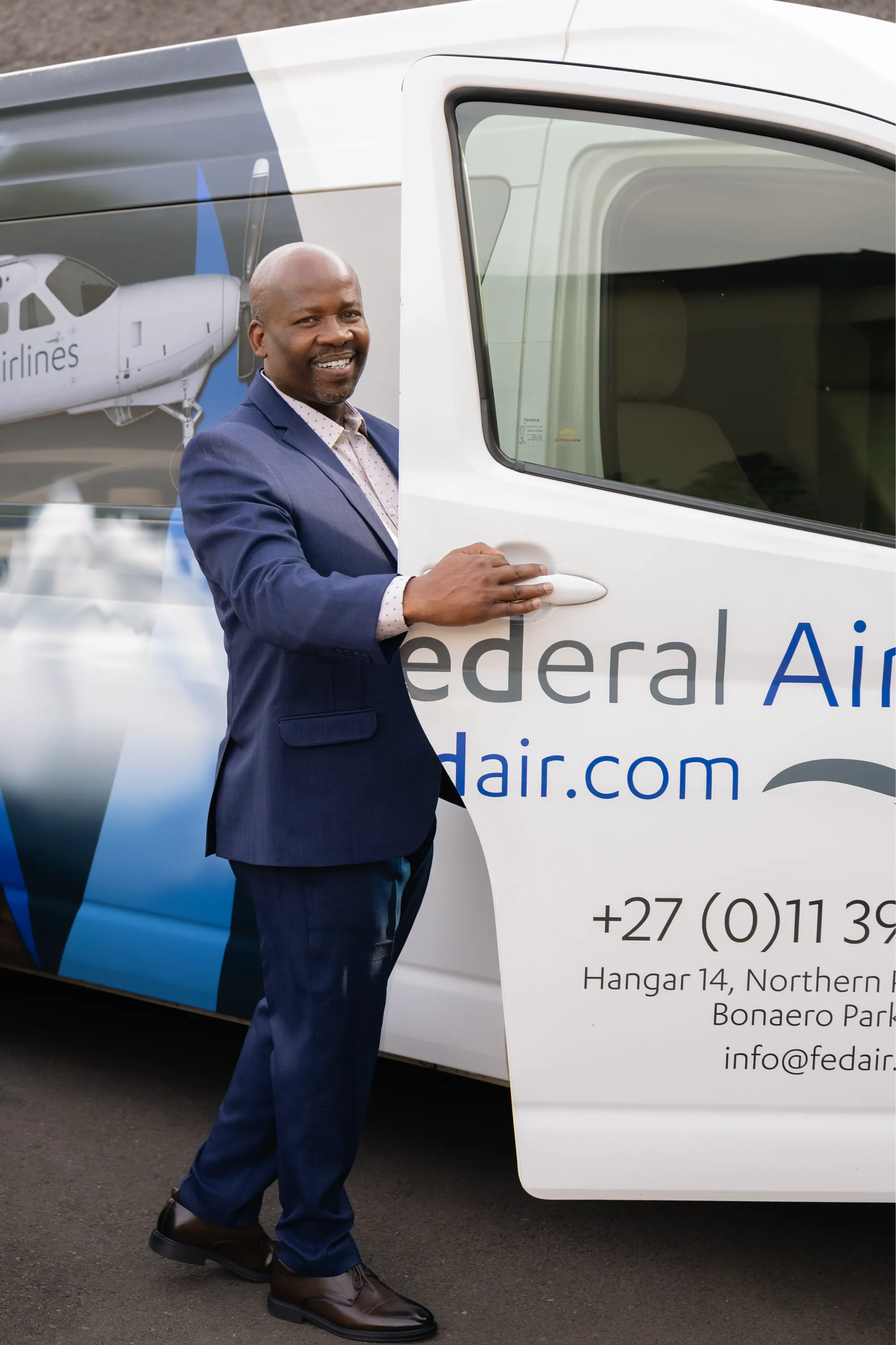Man dressed in an Imagemakers suit beside a Federal Airlines vehicle